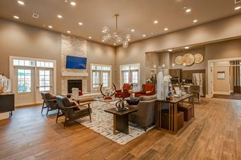 a large living room with a fireplace and a large dining room in the background